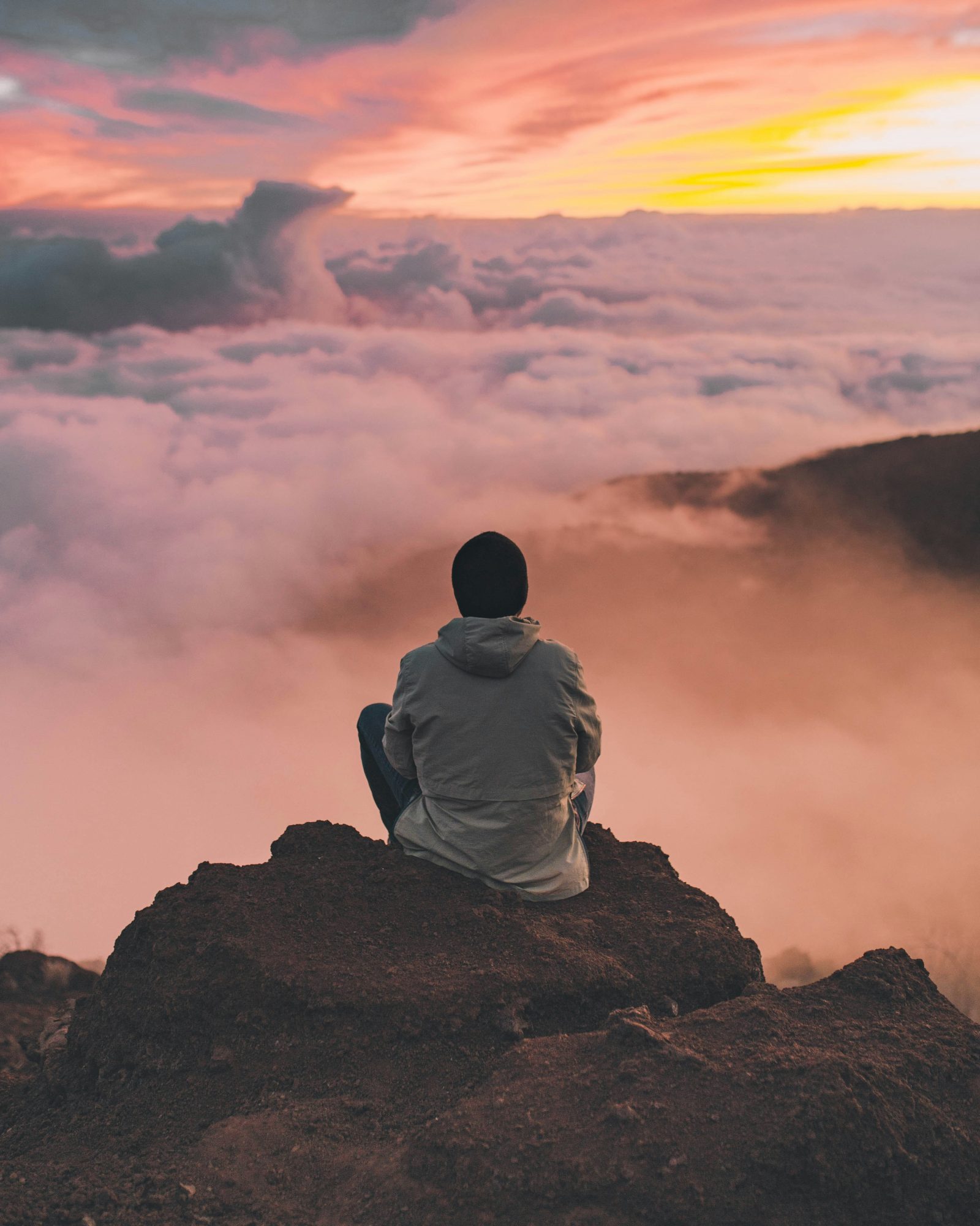 man meditating on a mountain